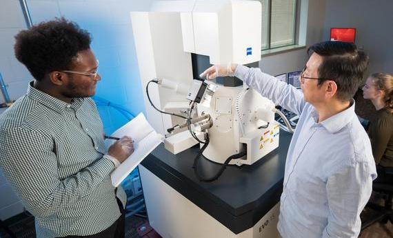 Two people using an electron microscope in 뿪¼'s College of Liberal Arts
