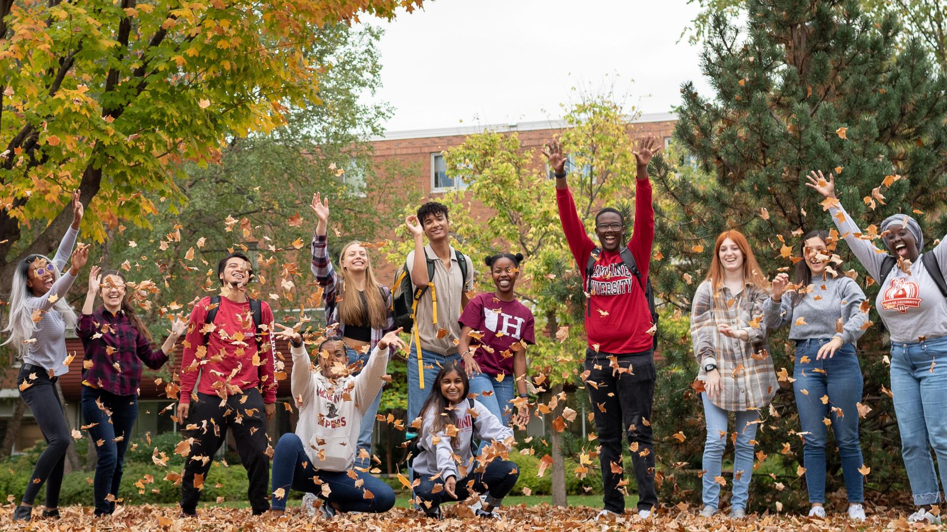  뿪¼ happy students at 뿪¼ during the fall blowing the leafs